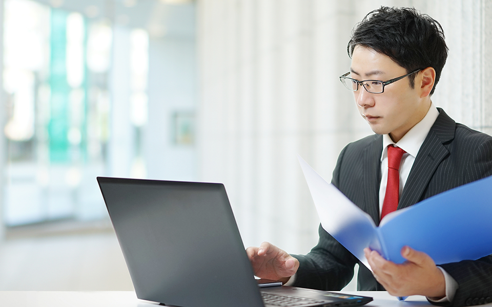 申請書と基準表を見比べながら不備を確認する担当者